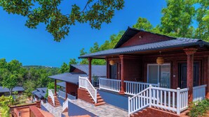 A traditional red building with a balcony, white railings, and a stone pathway leading to the entrance. - Zo Selections Gokarna by Zostel (Gokarna)