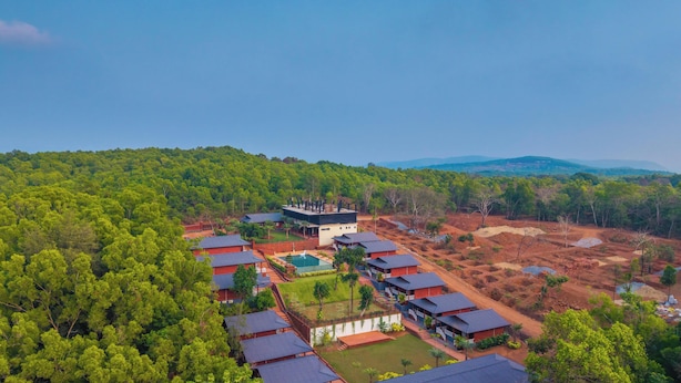 A resort with multiple bungalow-style buildings, a swimming pool, and a large building with a flat roof. - Zo Selections Gokarna by Zostel (Gokarna)