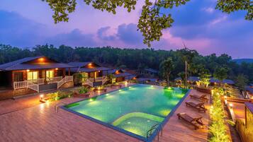 A resort with a swimming pool, wooden deck, and multiple buildings with balconies.