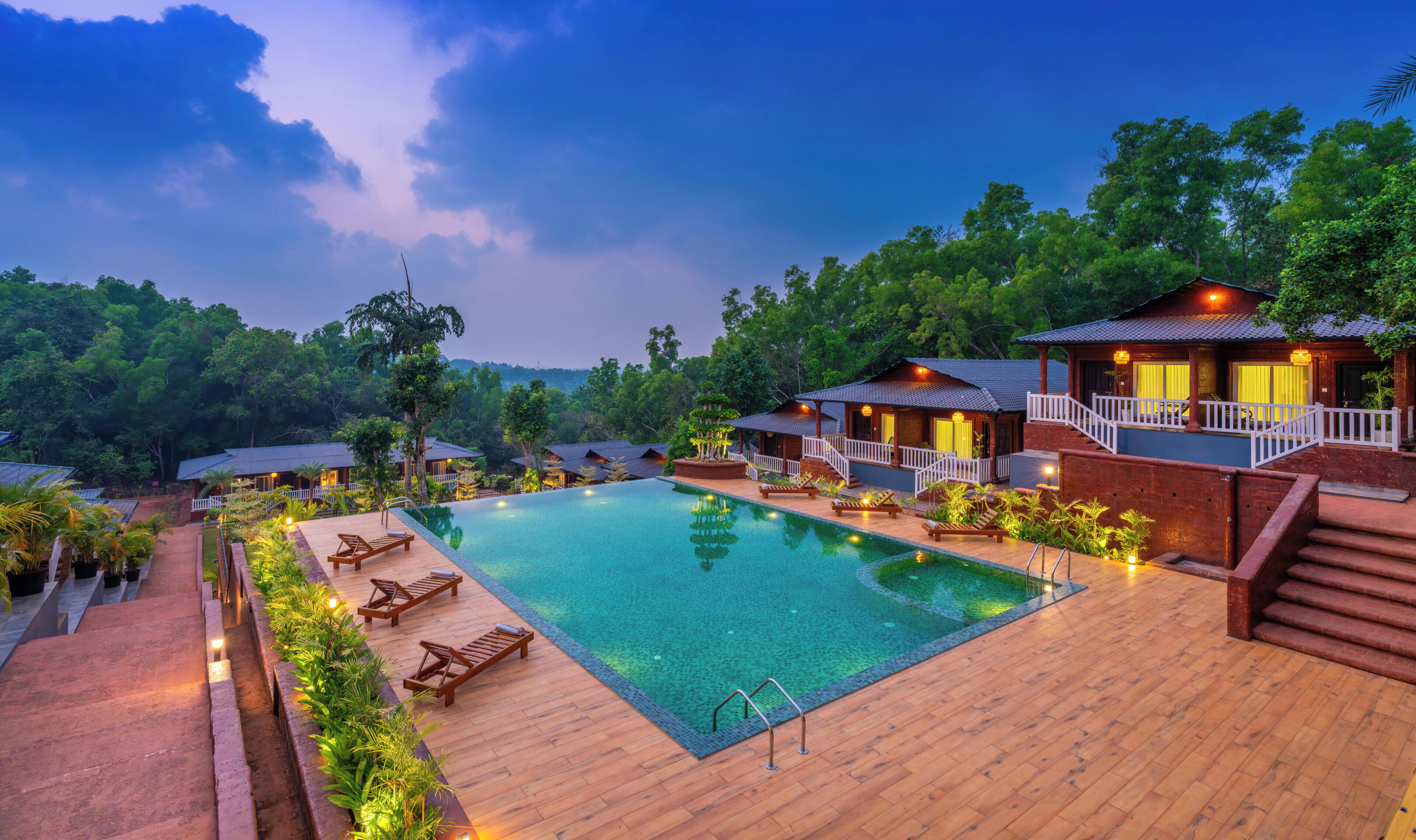A resort with a swimming pool, wooden deck, and multiple guest villas.