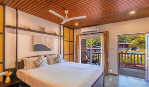 A bedroom with a bed, a ceiling fan, a window, and an air conditioning unit. - Zo Selections Gokarna by Zostel (Gokarna)
