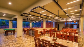 A restaurant with a pool table, wooden chairs, and a bar area. - Zo Selections Gokarna by Zostel (Gokarna)