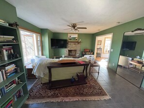 Una sala de estar con chimenea, televisión y estantería.