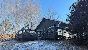 A two-story house with a covered porch and a wooden deck. - Serene 3-bedroom bungalow with AC in charming Canton (Canton)
