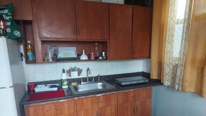 A kitchen with wooden cabinets, a stainless steel sink, and a microwave. - Grove 3 (Irvington)