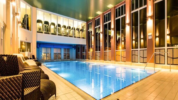 A swimming pool with lounge chairs and a covered seating area. - Forest Pines Spa and Golf Resort (Brigg)