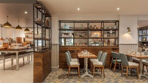 A dining area with a central table and chairs, surrounded by shelves with various items. - Forest Pines Spa and Golf Resort (Brigg)