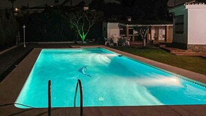 Et rektangulært swimmingpool med en klar, blå vandoverflade, omgivet af en belagt terrasse.