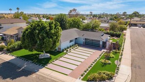 A residential property with a modern house, a well-maintained lawn, and a driveway.