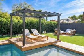 A backyard with a pool, wooden pergola, and lounge chairs. - Element By Avantstay Pool Firepit Game Room (Scottsdale)