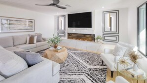 A modern living room with a sofa, coffee table, and a fireplace.