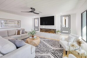 A modern living room with a sofa, coffee table, and a fireplace. - Element By Avantstay Pool Firepit Game Room (Scottsdale)