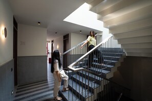 Un interior moderno con una escalera, un pasillo y una puerta marcada con el número 306.