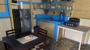 Una cucina compatta con frigorifero, fornello e piano di lavoro blu.