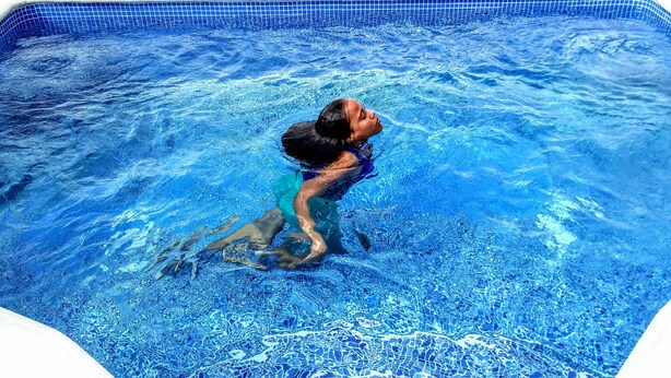 Una persona nuota in una piscina con acqua cristallina.