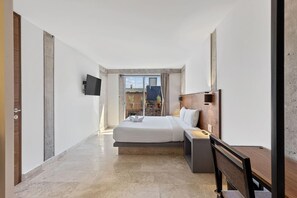Een moderne hotelkamer met een groot bed, een bureau en een televisie aan de muur.
