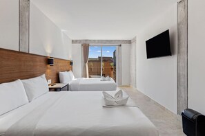 Une chambre d’hôtel avec deux lits, un téléviseur à écran plat et une vue sur l’extérieur.