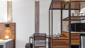 A compact kitchenette with a built-in stove, a small dining table, and a chair. - Morelos By Homirent (Cadereyta de Montes)