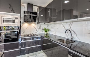 A modern kitchen with a built-in oven, microwave, and gas stove.