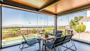 Un balcon avec une table et des chaises, un barbecue et une vue sur la campagne.