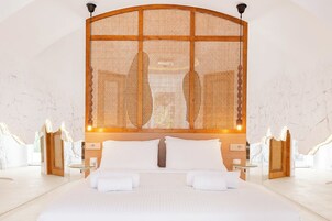 Un dormitorio espacioso con una cama grande, cabecera de madera y diseño moderno.