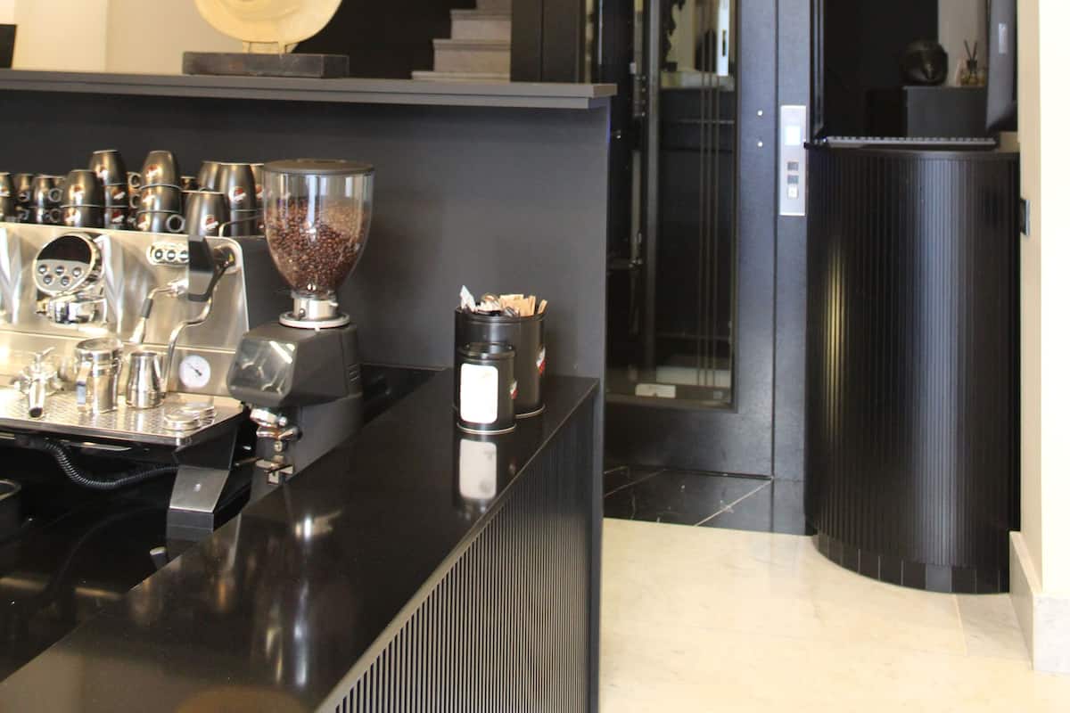 A modern lobby with a coffee machine, a heart-shaped decoration, and a staircase.