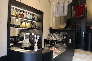 Una zona de bar con estantes llenos de botellas de licor, una máquina de café y una decoración con forma de corazón.