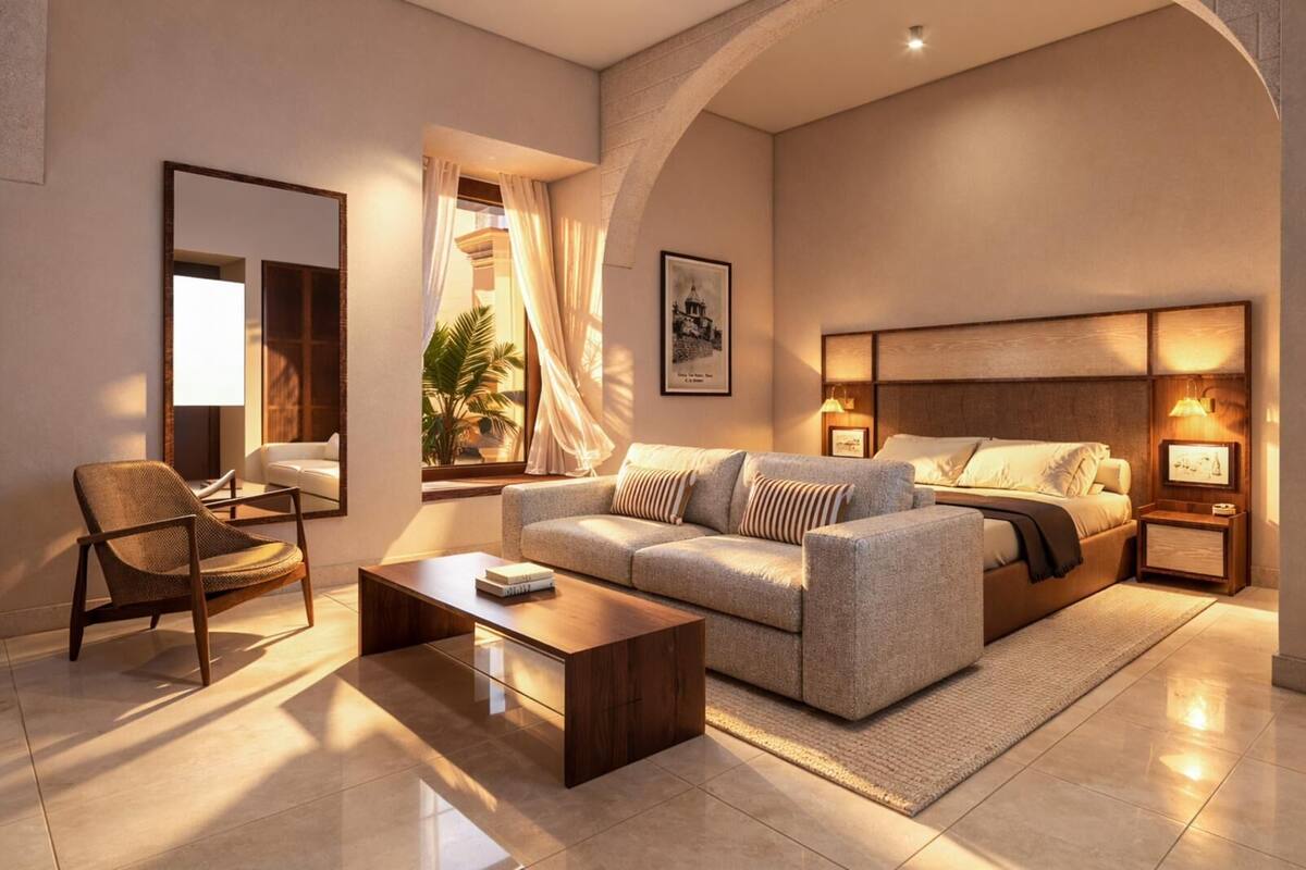 Ein modernes Hotelzimmer mit einer Couch, einem Sessel, einem Nachttisch, einer Lampe und einem Bett.