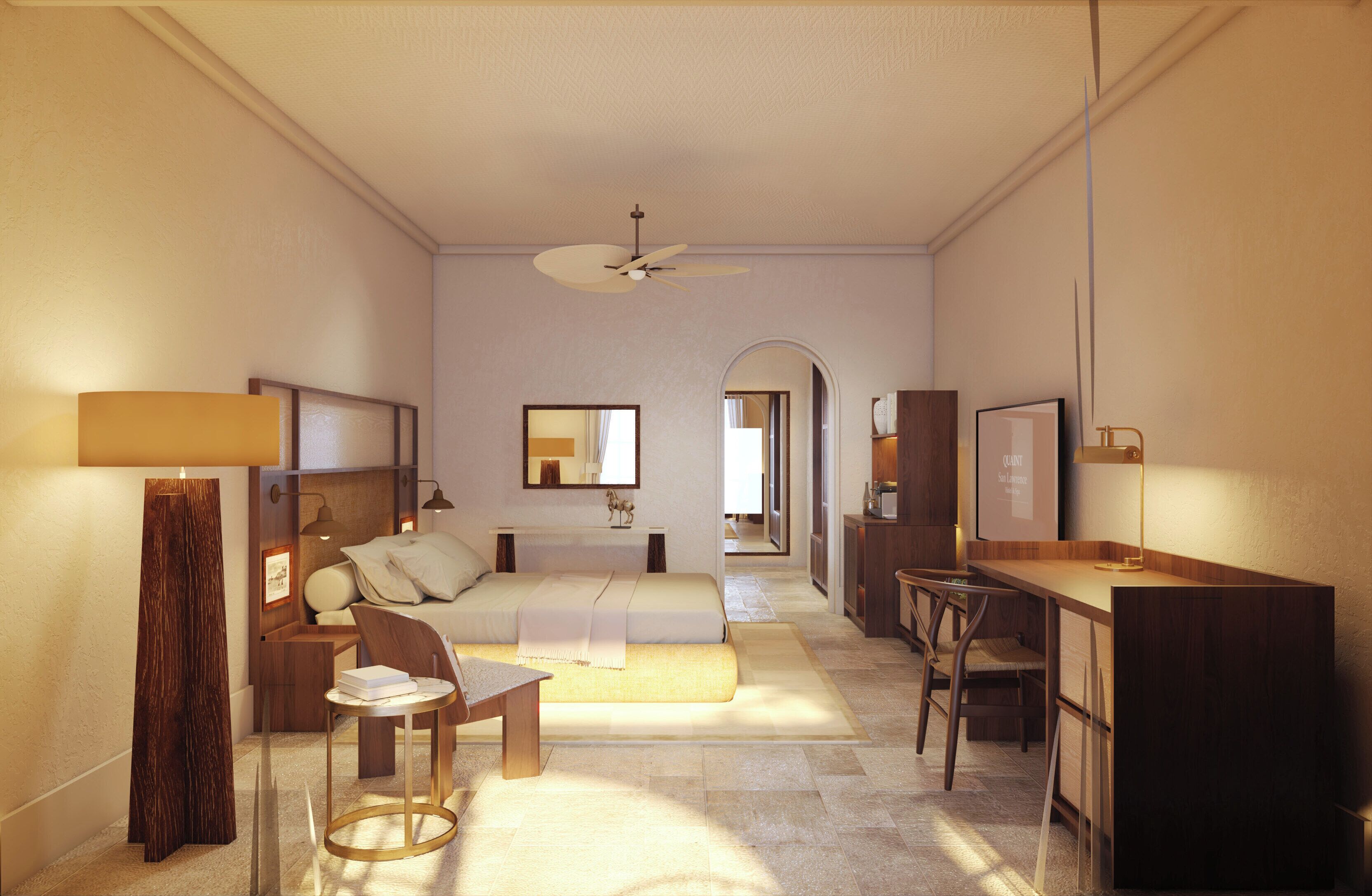 Une chambre d’hôtel équipée d’un lit, d’une table de chevet, d’une chaise, d’un bureau et d’un ventilateur de plafond.