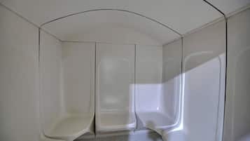 A modern, minimalist room with a curved ceiling and a central column.