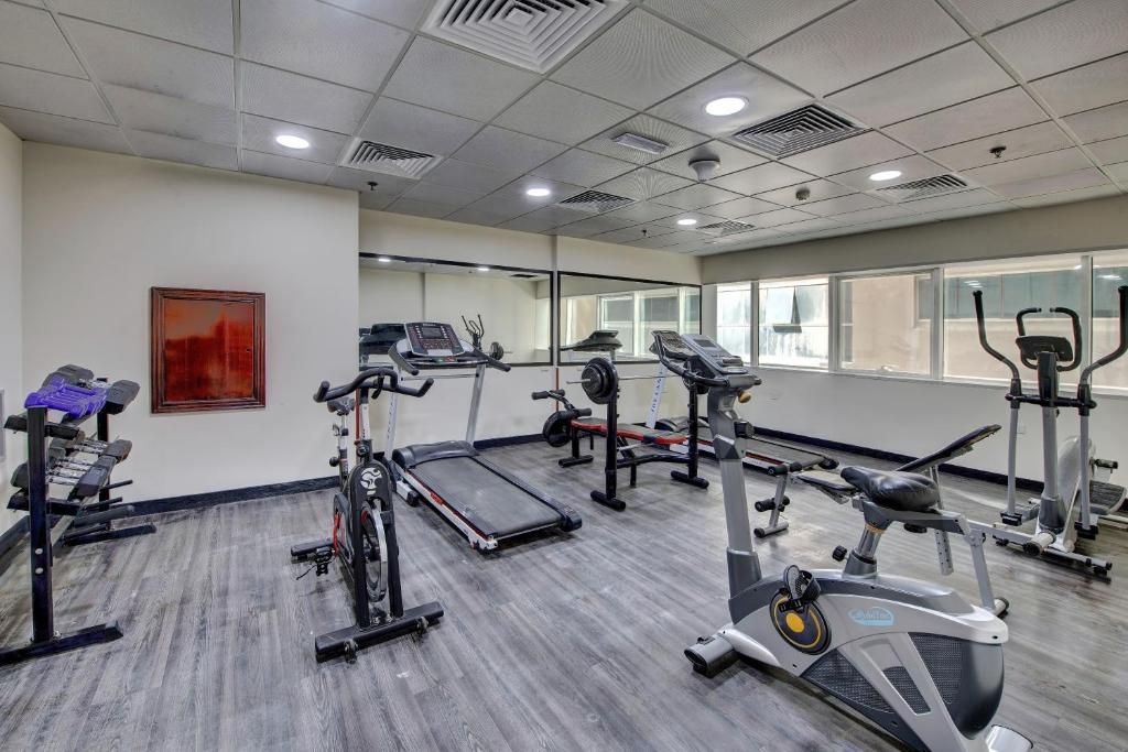 A gym with treadmills, elliptical machines, and weight stations.
