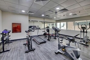 Ein Fitnessstudio mit Laufbändern, Crosstrainern und Gewichteinrichtungen.