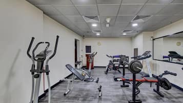 A gym with various exercise equipment including treadmills, elliptical machines, and weight benches.