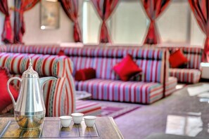 A room with striped sofas, a metallic coffee pot, and white cups on a tray. - City Stay Hotel Expo Center Sharjah (Sharjah)