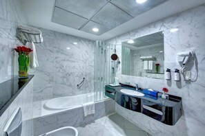 A modern bathroom with a glass-enclosed shower, a large mirror, and a vanity with a sink and countertop. - City Stay Hotel Expo Center Sharjah (Sharjah)