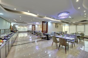 A spacious dining area with multiple tables and chairs, a buffet line, and decorative wall panels. - City Stay Hotel Expo Center Sharjah (Sharjah)
