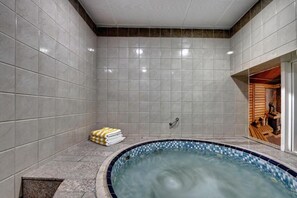 A spa room with a tiled wall, a small pool, and a wooden sauna visible through an open door. - City Stay Hotel Expo Center Sharjah (Sharjah)