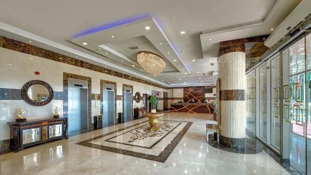 A spacious lobby with a marble floor, a central chandelier, and a reception desk. - City Stay Hotel Expo Center Sharjah (Sharjah)