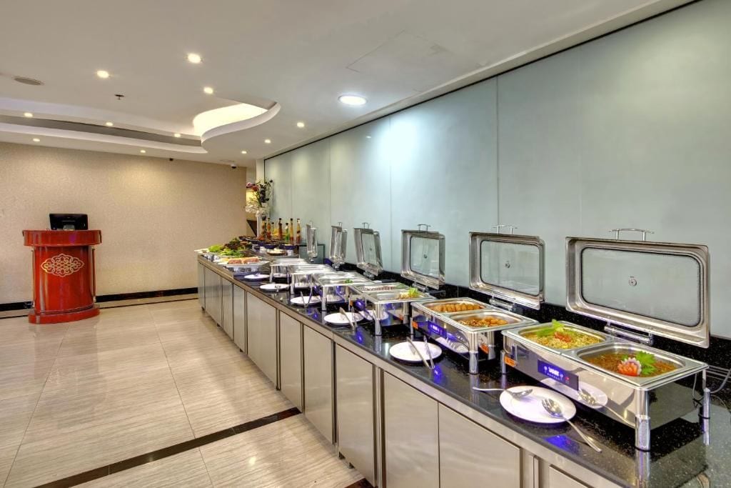 A buffet setup with multiple food stations, a podium, and a tiled floor.