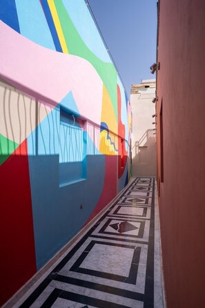 A corridor with a colorful mural on the wall and a patterned floor. - Zen Zone Boutique Riad & Spa (Marrakech)