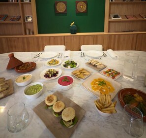 A dining table set with various dishes, including salads, bread, and a plate of fries. - Zen Zone Boutique Riad & Spa (Marrakech)