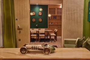 A modern interior with a dining area, a green accent wall, and a unique sculpture on the table. - Zen Zone Boutique Riad & Spa (Marrakech)