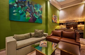 A modern living room with green walls, a beige sofa, a brown leather couch, and abstract paintings. - Zen Zone Boutique Riad & Spa (Marrakech)