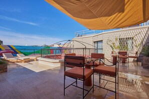 A rooftop terrace with outdoor seating, a view of the city, and a covered area. - Zen Zone Boutique Riad & Spa (Marrakech)