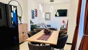 Een moderne eetruimte met een houten tafel, zes stoelen en een kleurrijke geweven placemat.