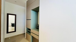 Una habitación con espejo, escritorio y estanterías empotradas.