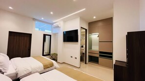 Una habitación de hotel moderna con cama, televisor, espejo y armario.
