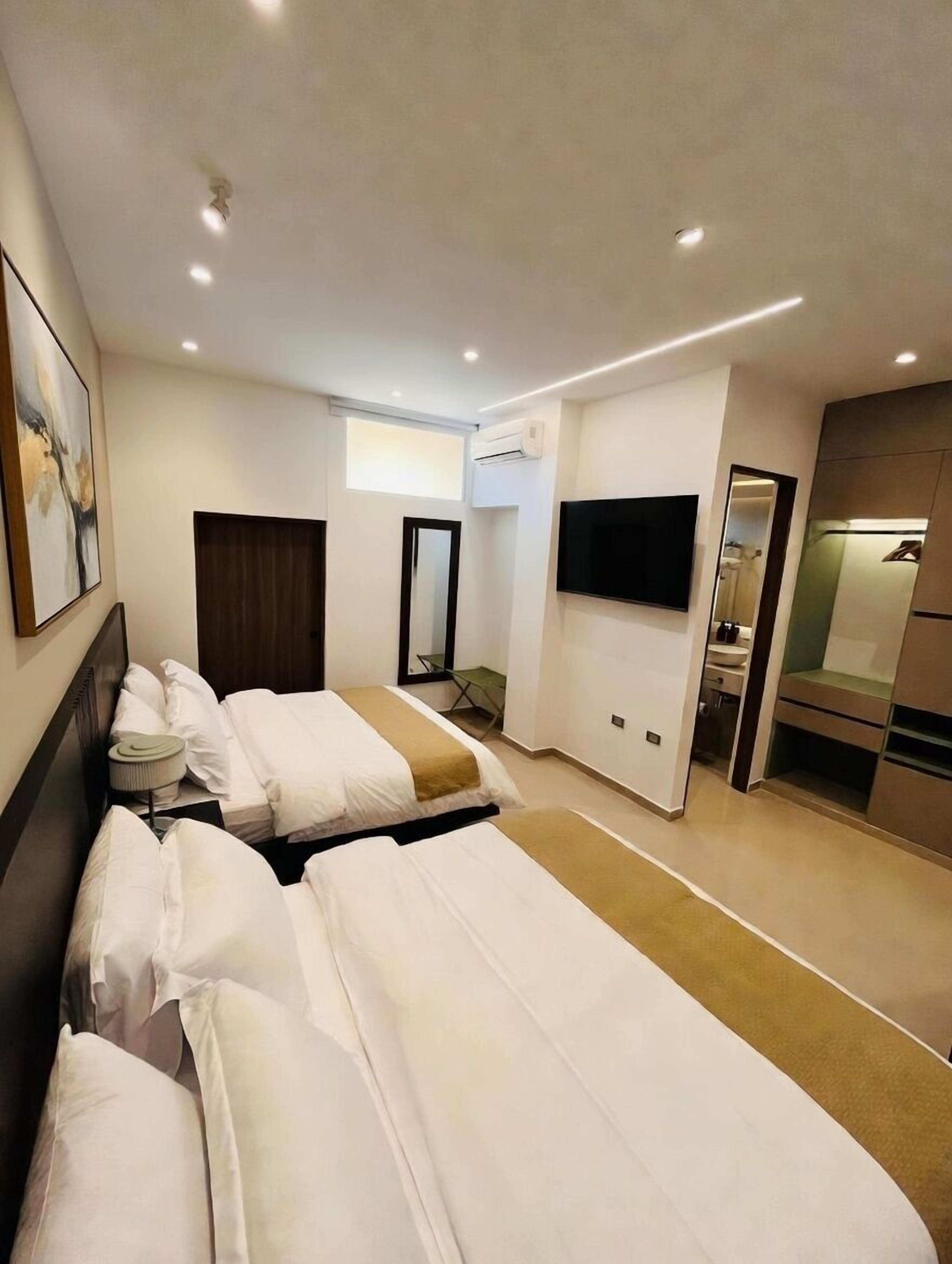 Une chambre d’hôtel dotée d’un grand lit, d’une télévision à écran plat, de la climatisation et d’un petit coin salon.