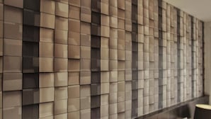 Un mur moderne orné d’un motif géométrique composé de panneaux carrés.