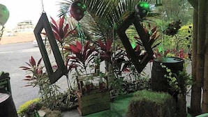 Un espace jardin aménagé avec différentes plantes et des éléments décoratifs, notamment une structure en bois et une petite table.